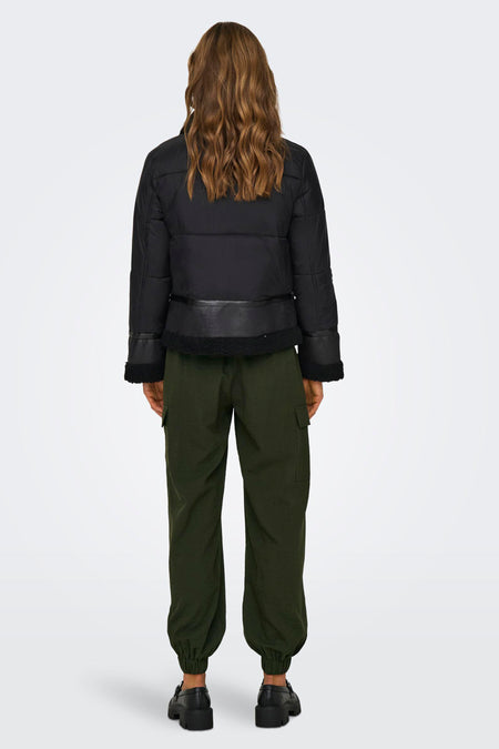 Zwarte korte jas van ONLY, met kraag van imitatiebont en groene cargo broek.
