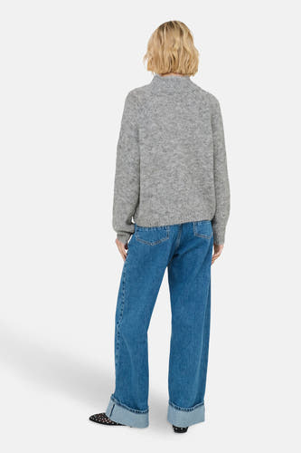 Sweat-shirt gris à col montant de JDY, avec des manches longues, associé à des jeans bleus à taille haute.