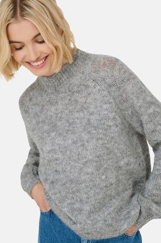 Sweat-shirt gris à col montant de JDY, avec des détails côtelés fins et une paire de jeans visible.