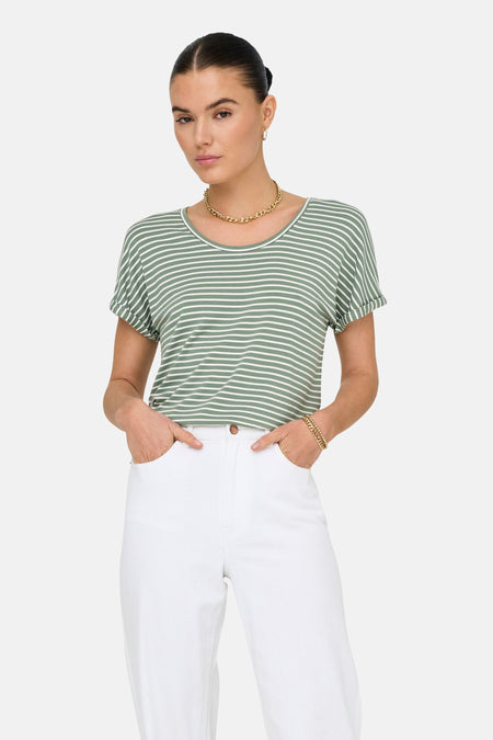 T-shirt vert à manches courtes de JDY, avec des rayures horizontales blanches, un col rond et des manches retroussées, porté avec une chaîne dorée et un pantalon blanc.