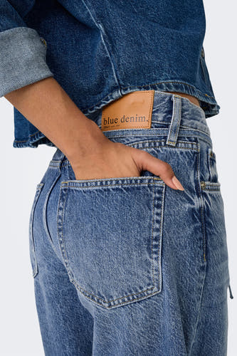 Jean bleu marine droit en denim de ONLY, avec poche arrière et main dans la poche.