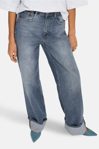 Jeanon denim bleu délavé de ONLY, avec des poches froncées et associés à des escarpins bleus.