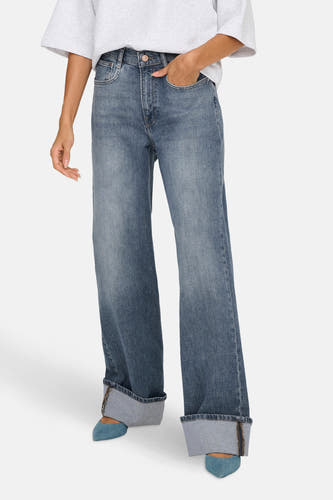 Jean bleu moyen large d'ONLY, avec des poches rabattues et associé à des chaussures bleues.