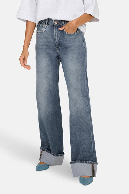 Jean bleu moyen large d'ONLY, avec des poches rabattues et associé à des chaussures bleues.
