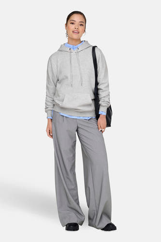 Pull gris à capuche ONLY, avec cordon de serrage et associé à une blouse et un pantalon.