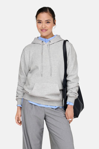 Pull-over gris avec capuche ONLY®, avec cordon et poche, porté sur une chemise bleue et un pantalon gris.