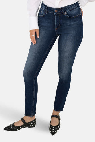 Jean skinny en denim bleu marine de ONLY®, associé à une chemise blanche et des chaussures noires à talons.