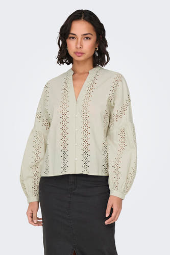 Blouse écru à longues manches de ONLY, avec des détails brodés et des manches effilochées, associée à une jupe noire.