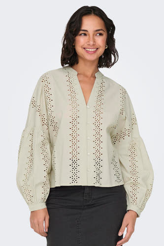 Blouse écru à longues manches de ONLY, avec des détails brodés et des manches bouffantes associées à un jean noir.