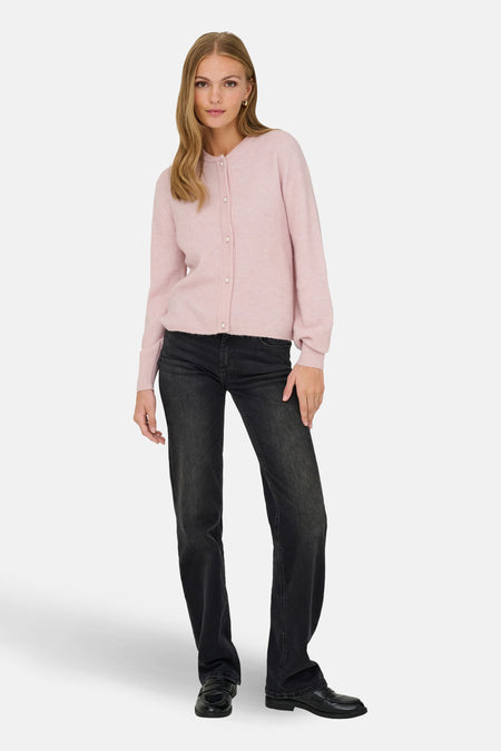 Roze cardigan van JDY met lange mouwen en parelmoeren knoopjes, gedragen over een zwarte jeans met zwarte loafers.
