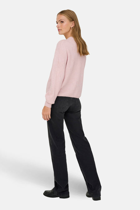 Cardigan rose de JDY, avec des manches longues, porté avec des jeans noirs et des chaussures.