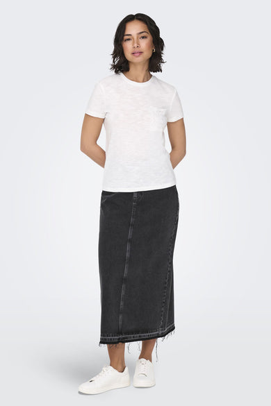 Longue jupe en denim noir de ONLY®, avec un ourlet froncé et des baskets blanches.