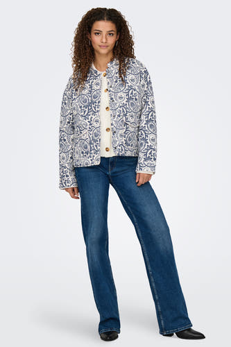 Blauw jas van ONLY met paisley-patroon, gedragen over een crèmekleurig vest met knopen en blauwe jeans.