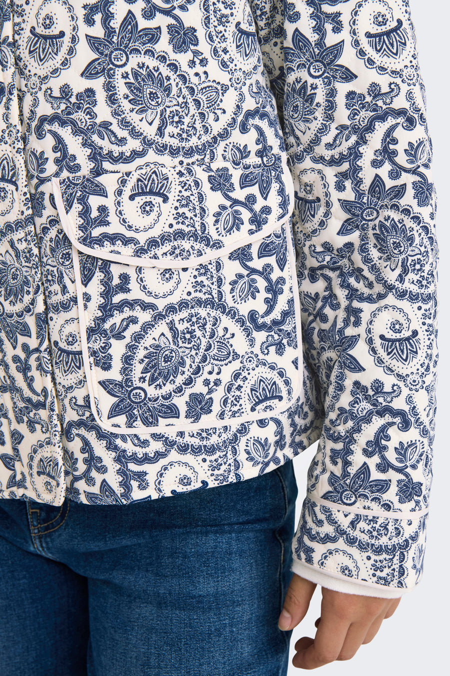 Veste courte bleue de ONLY®, avec motif cachemire, détail de poche et combinée avec un jean.