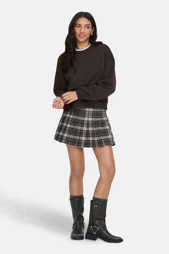 Multicolor korte rok van ONLY, met ruitpatroon en gecombineerd met een donkerbruine sweater en hoge laarzen.
