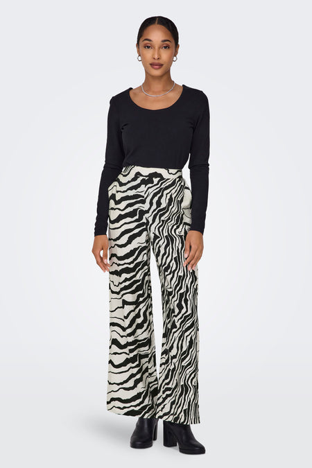 Witte broek van ONLY, met een zebraprint en gecombineerd met een zwart shirt en zwarte laarzen.

