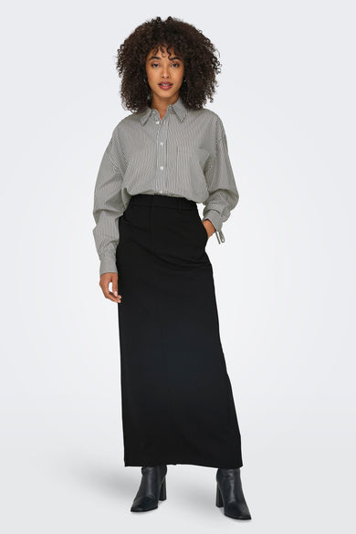 Chemise grise à manches longues de ONLY, avec un motif rayé et portée avec une jupe noire et des bottes.