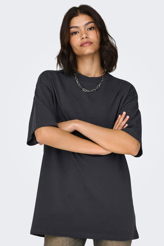T-shirt gris à manches courtes de ONLY, avec une chaîne argentée et des bras croisés.