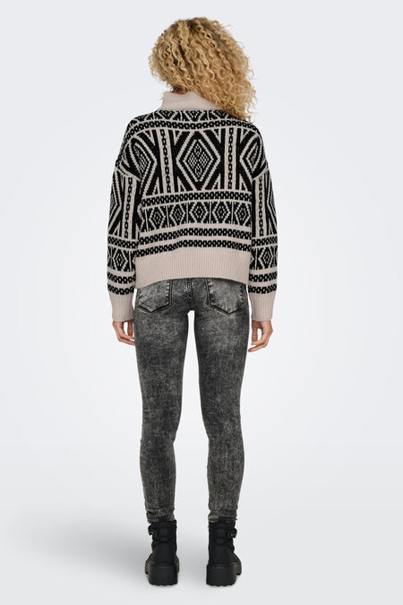 Ecru trui met rolkraag van ONLY, met een zwart-wit aztekenpatroon, gecombineerd met grijze jeans en zwarte laarzen.