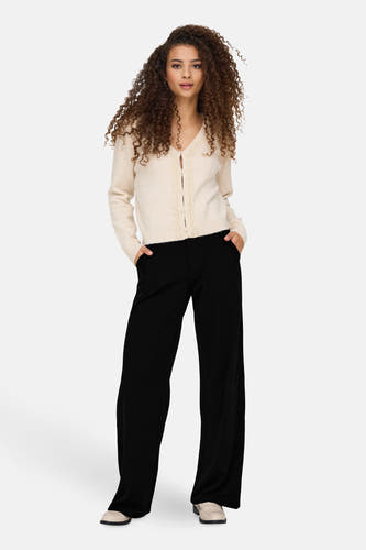 Pantalon noir de JDY, avec des jambes larges et des poches, associé à un gilet tricoté.