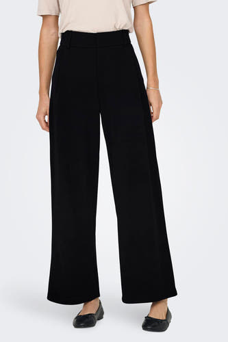 Pantalon noir de JDY, avec les mains dans les poches et une devanture pliée.
