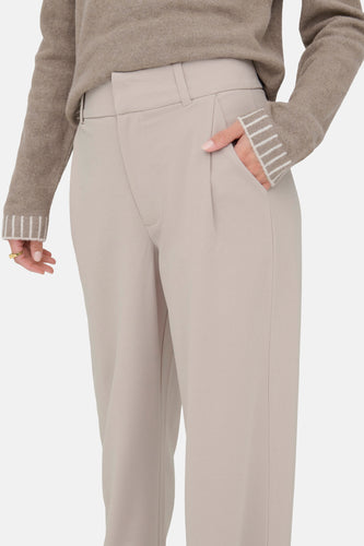 Beige pantalon met wijde pijpen en een bijpassende trui.