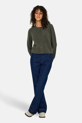 Cardigan kaki de JDY, avec des manches longues et une fermeture à boutons, associé à des jeans bleu marine et des chaussures crème.