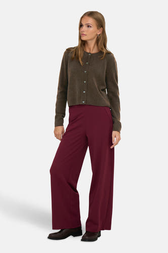 Veste brune de JDY, avec des manches longues et une fermeture à boutons, associée à un pantalon bordeaux large et des chaussures brunes foncées.