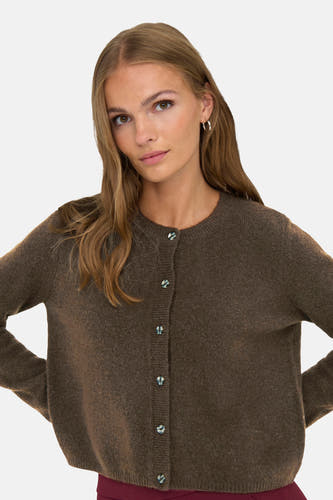 Cardigan marron de JDY, avec des manches longues et une fermeture à boutons, porté avec des boucles d'oreilles en argent.