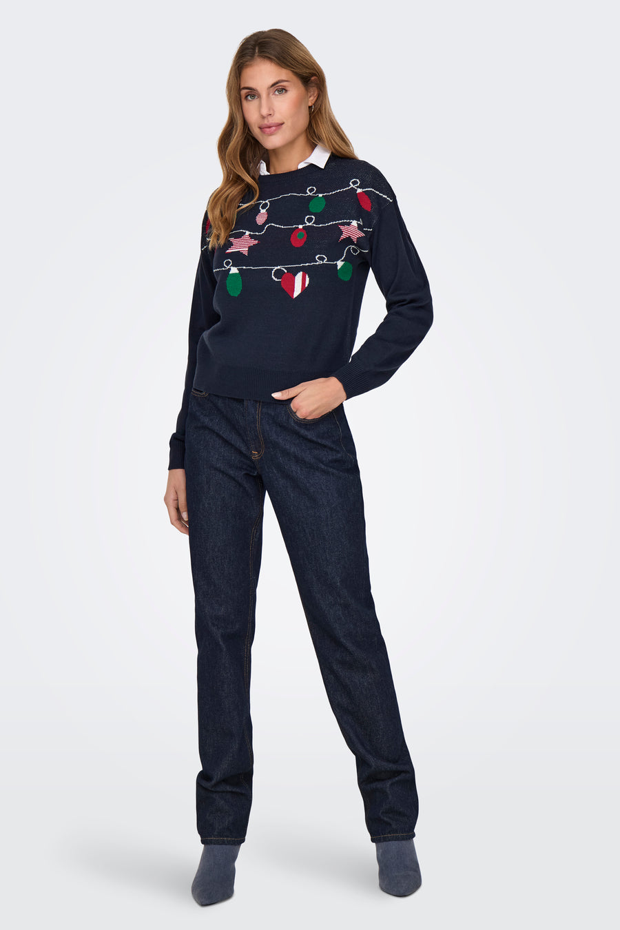 Blauwe trui met ronde hals van ONLY, met kerstverlichting en gedragen met een wit overhemd en donkere jeans.
