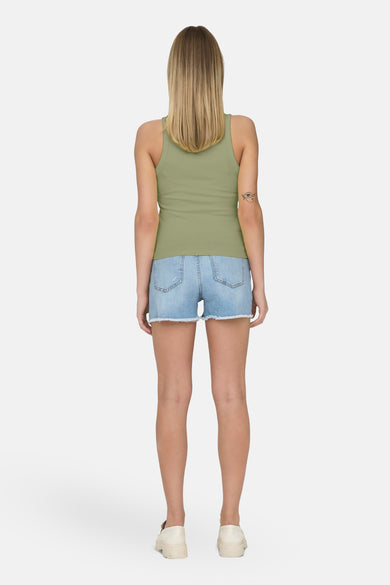 T-shirt kaki ONLY, avec un design sans manches, associé à des shorts en denim et des loafers blancs.