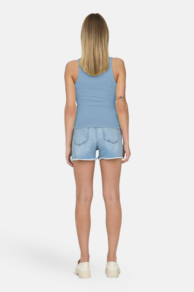 Blauwe singlet van ONLY, met een tatoeage op de arm, gedragen met een spijkerbroek.
