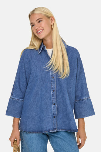 T-shirt en jeans de denim bleu mid, ONLY ONLY avec fermeture boutons et manches trois-quarts, porté avec un t-shirt blanc et des jeans bleus.