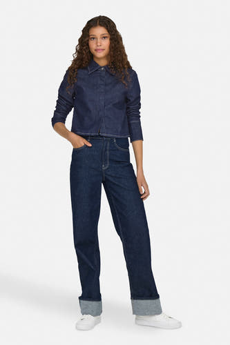 Jean en denim bleu marine avec des jambes larges de ONLY, avec des ourlets relevés et des baskets blanches.