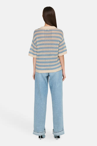 Polo rayé bleu de JDY avec des manches courtes, associé à des jeans larges et des baskets.