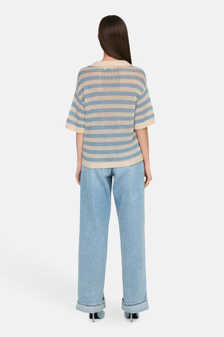 Polo rayé bleu de JDY avec des manches courtes, associé à des jeans larges et des baskets.