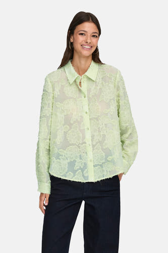 Chemise verte à manches longues de JDY, avec un motif floral et portée avec un jean foncé et des talons.