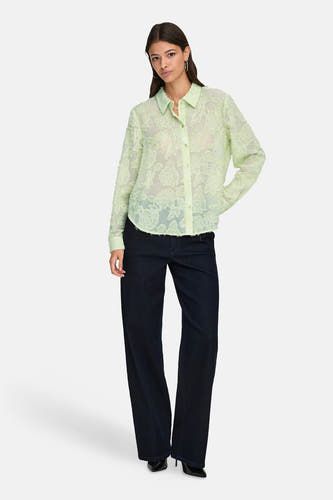 Groen hemd met lange mouwen van JDY, met een bloemmotief en gedragen met donkere jeans en hakken.
