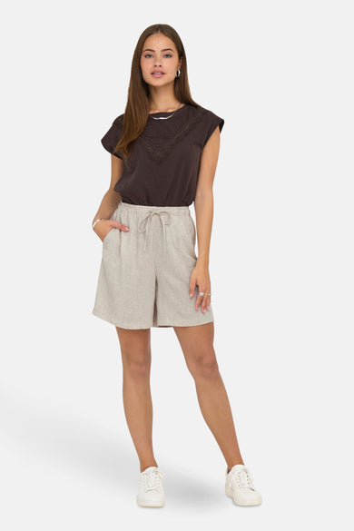 Crème court ONLY, avec cordon de serrage et poches, associé à une chemise brune et des baskets blanches.