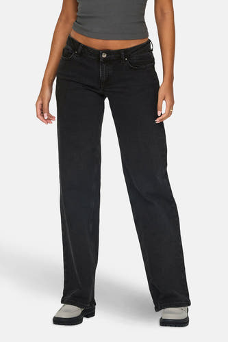 Jean délavé gris foncé d'ONLY, avec un haut gris et des chaussures grises.