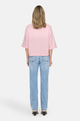 T-shirt rose avec col rond de ONLY, associé à un short en denim et des talons hauts.