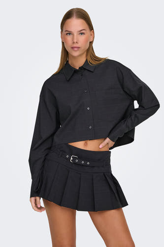 Chemise grise à manches longues de ONLY, associée à une jupe noire et des chaussures à rayures.