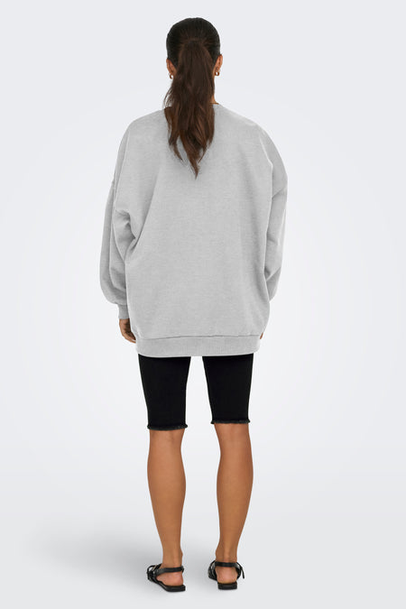 Grijze sweater van ONLY, gedragen met zwarte fietsbroek en sandalen, achterkant.
