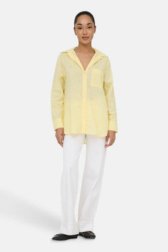 Geel hemd met lange mouwen van ONLY®, gedragen met een witte broek en zwarte schoenen.