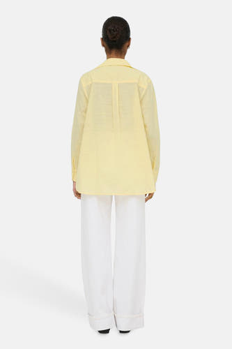 Chemise jaune à manches longues ONLY, vue de dos, associée à un pantalon blanc.
