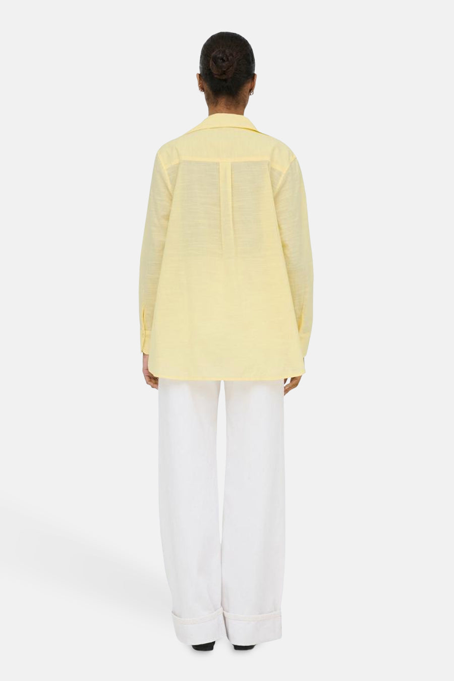 Chemise jaune à manches longues ONLY, vue de dos, associée à un pantalon blanc.