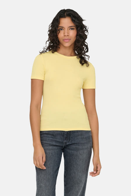 T-shirt jaune à manches courtes de ONLY®, porté avec des jeans foncés et des bottes noires.