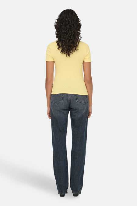 Achterkant van een vrouw met een geel shirt en donkere jeans op een witte achtergrond.