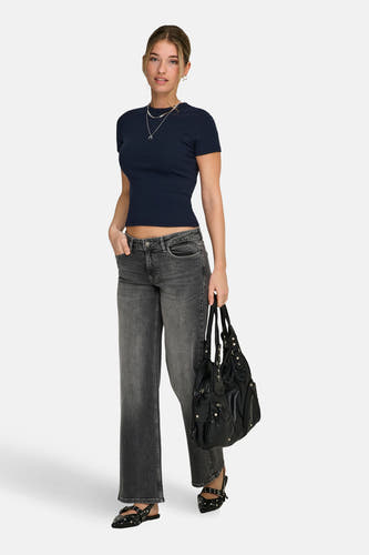 Blauw T-shirt met korte mouwen van ONLY®, gedragen met grijze jeans en zwarte handtas en schoenen.