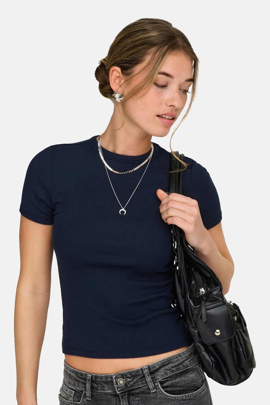 T-shirt bleu à manches courtes de ONLY, avec structure côtelée et porté avec un jean gris, des chaînes argentées et un sac noir.